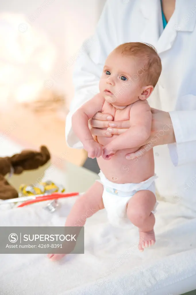 2 months old baby medical examination. The pediatrician is holding the baby during a test for the stepping or walking reflex.