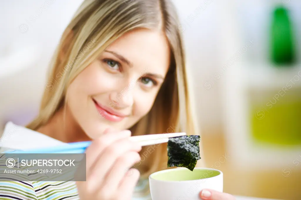 Woman eating edible seaweed.