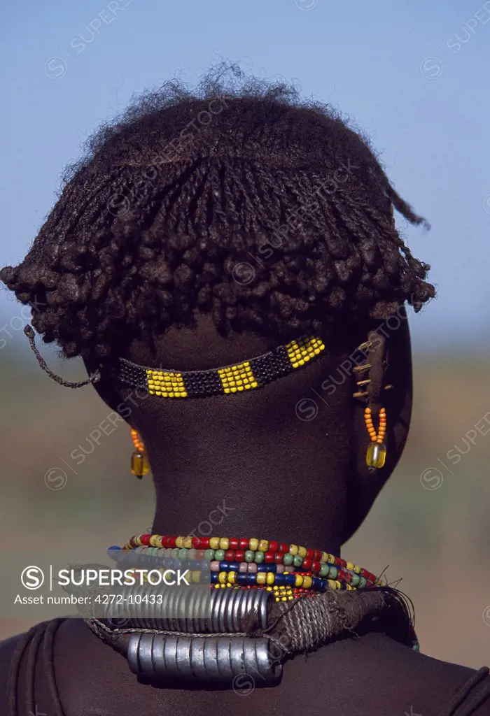 A young Dassanech girl wears a beautiful array of beaded necklaces, some secured at the back by metal rings, and a beaded headband.  Her ears are pierced several times, the holes are kept open by small wooden plugs.   Much the largest of the tribes in the Omo Valley numbering around 50,000, the Dassanech (also known as the Galeb, Changila or Merille) are Nilotic pastoralists and agriculturalists.