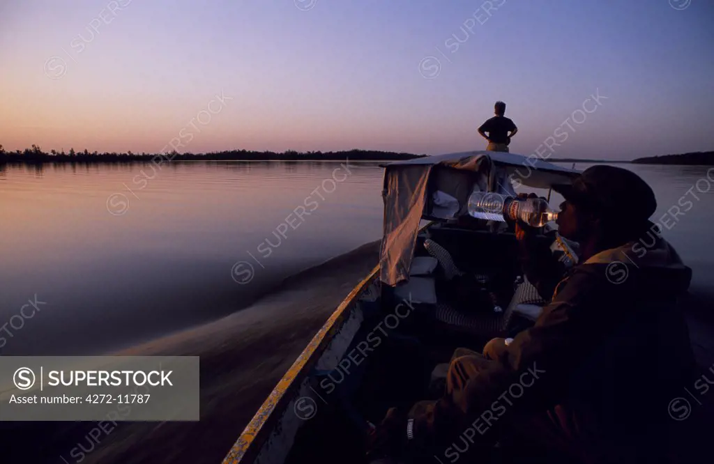 The Gambia, Gambia River. A tourist skiff  speeds upriver towards Janjenbureh (Georgetown).