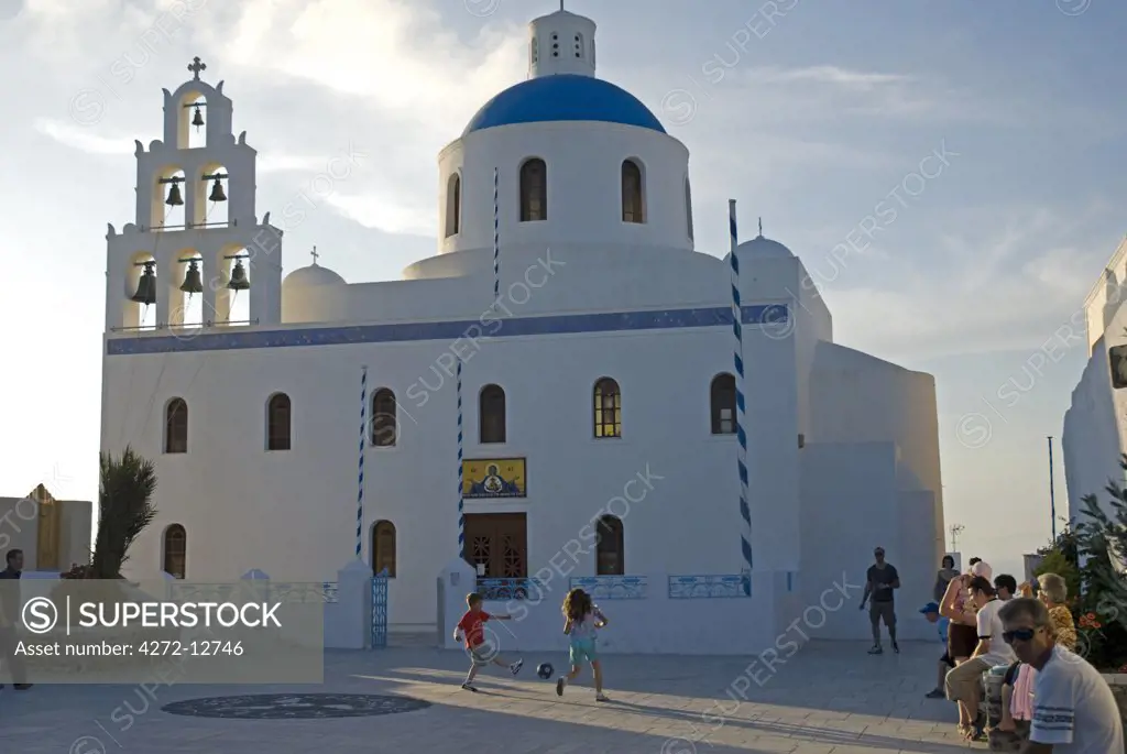 Greece, Santorini, Oia. Children playing  in the courtyard of a church in Oia.