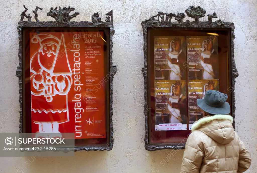 Venice, Veneto, Italy; A passerby looking at the theatre bill