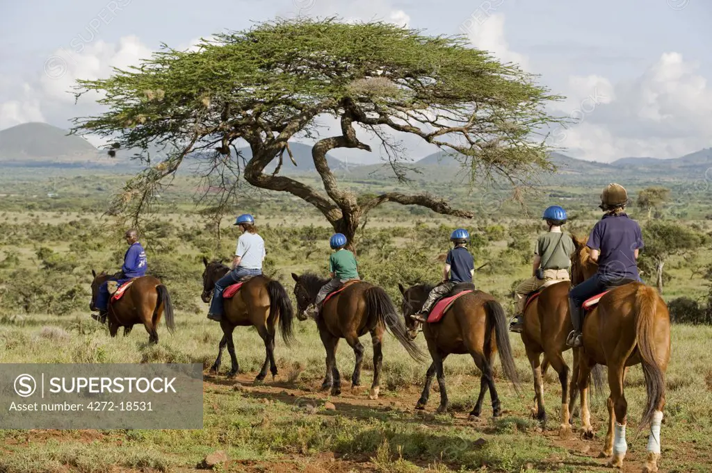 Kenya, Laikipia, Lewa Downs.  A family on a horse riding safari.