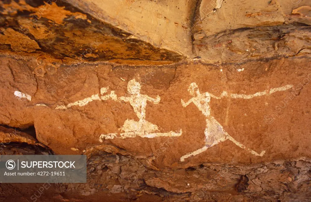 Libya, Fezzan, Jebel Akakus. A pair of running figures painted onto the walls of Uan Muhuggiag, one of Wadi Teshuinat's caves.