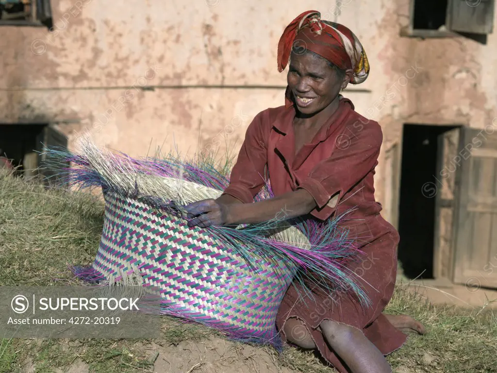 A Malagasy woman weaves a basket from raffia palm.