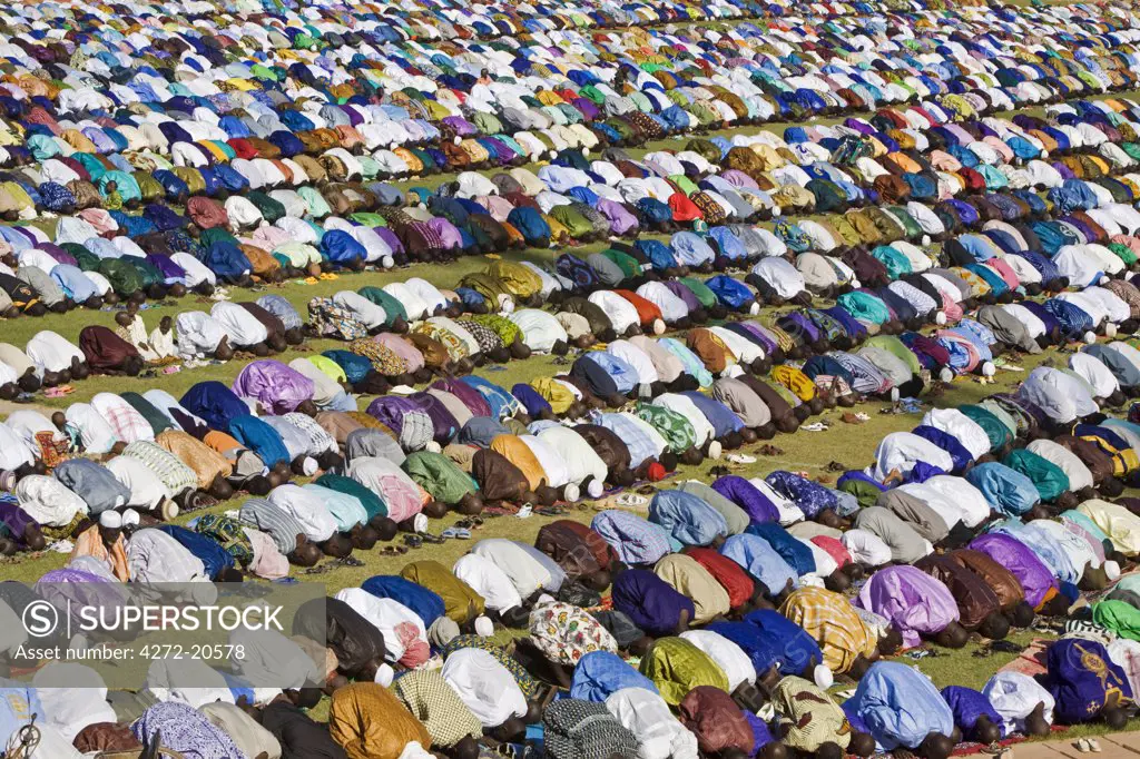 Mali, Mopti. A huge gathering of brilliantly dressed Muslim men pray to Allah at an open-air service to commemorate the end of the Muslim holy month of Ramadan.  This celebration is known as Idd el Fitr.