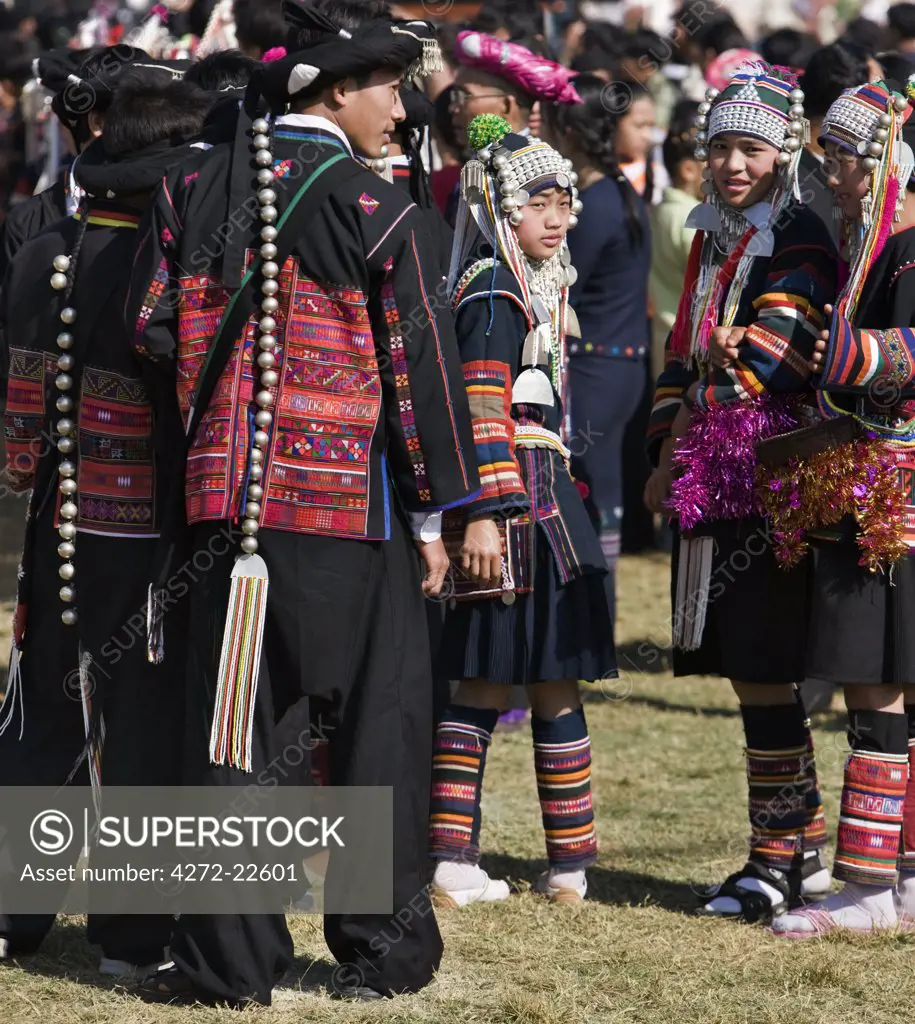 Myanmar, Burma, Kengtung. A gathering of Akha men and women wearing traditional costumes at an Akha festival.