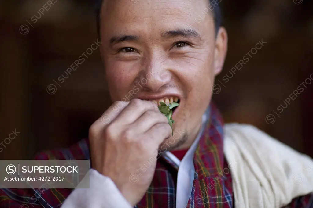 A Bhutanese man in a Gho eating Betel nut in Bhutan