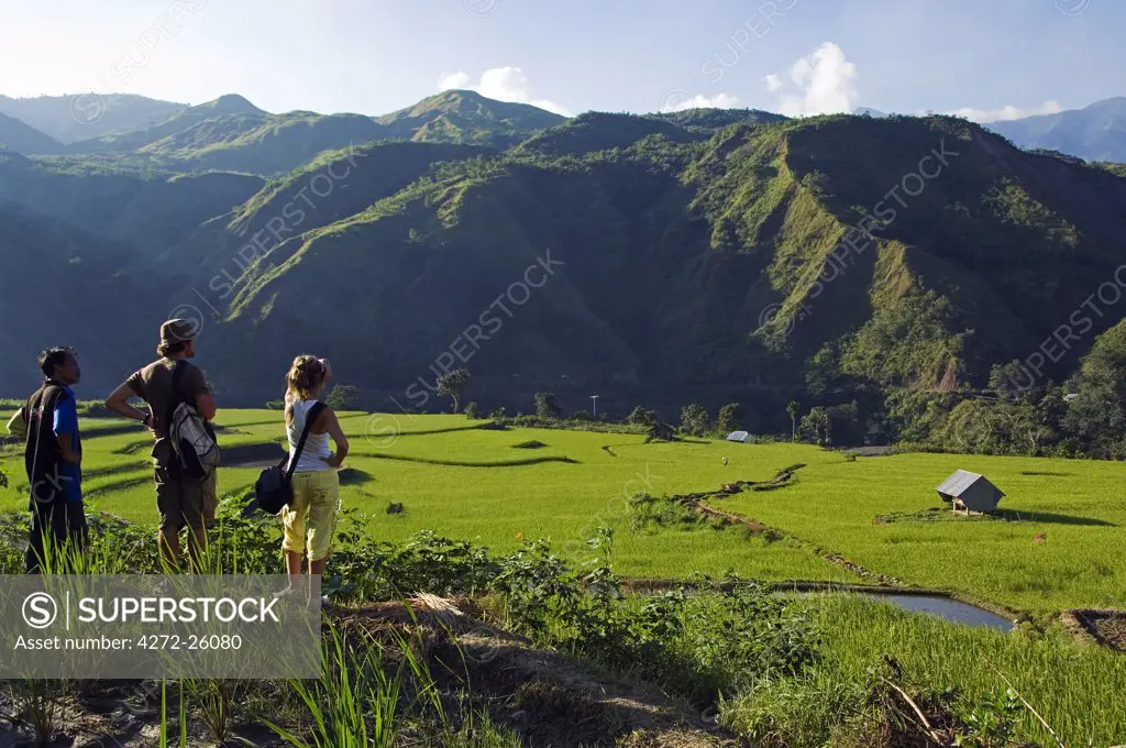 Philippines, Luzon Island, The Cordillera Mountains, Kalinga Province, Tinglayan. Western tourists and guide looking at rice terraces in Luplula village.