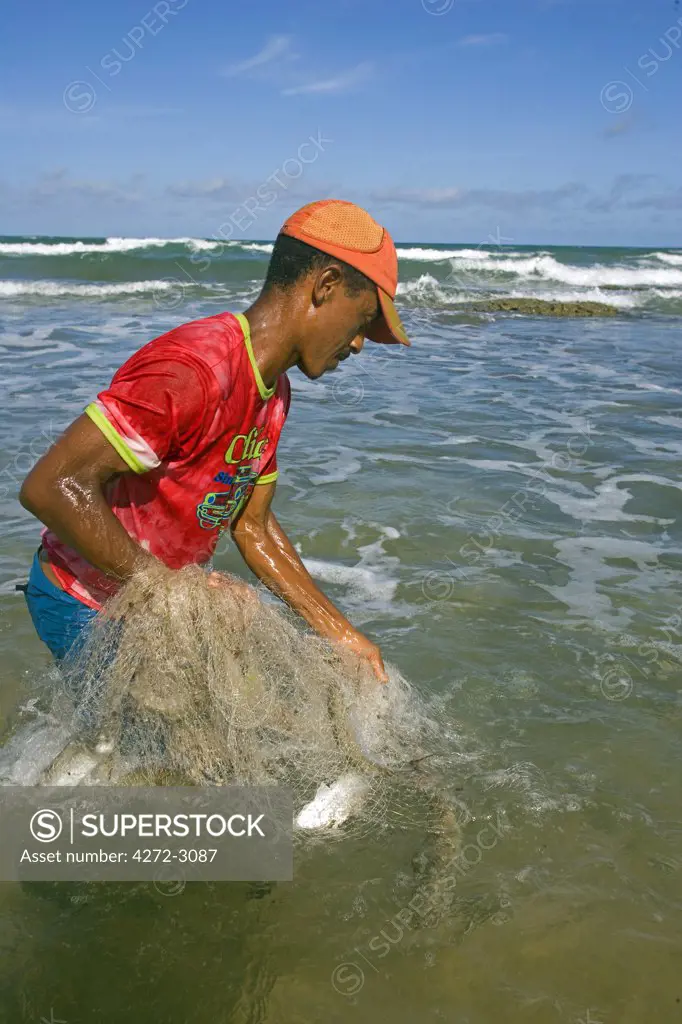 Net fisherman on the shore of the Atlantic Coast of the Tinhare archipelago, Bahia, north east Brazil