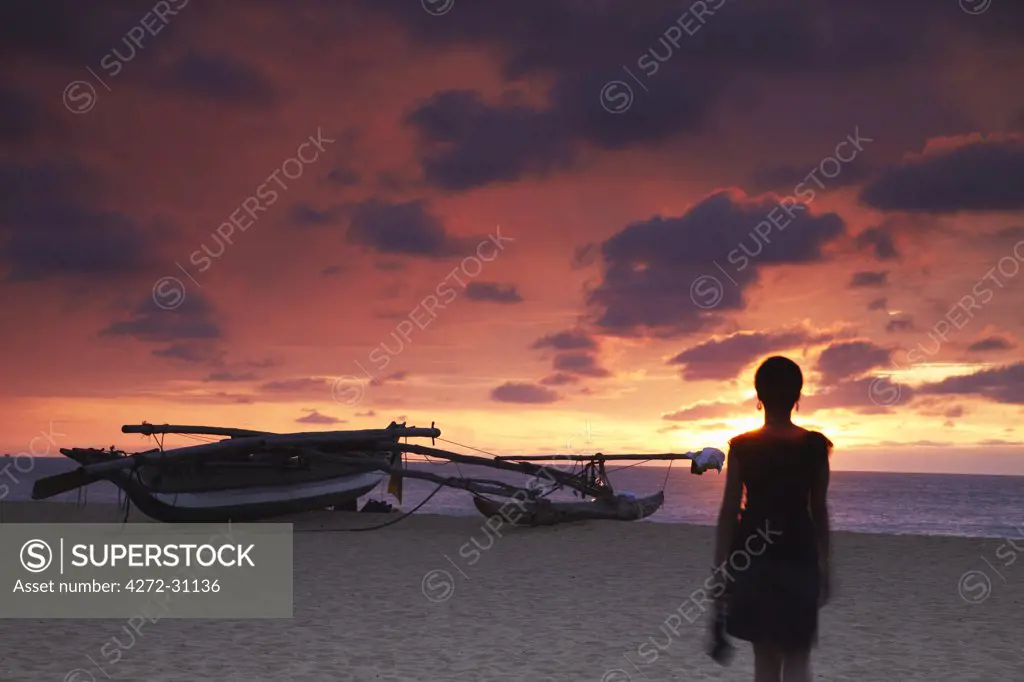 Woman walking on beach at sunset, Negombo, Sri Lanka (MR)