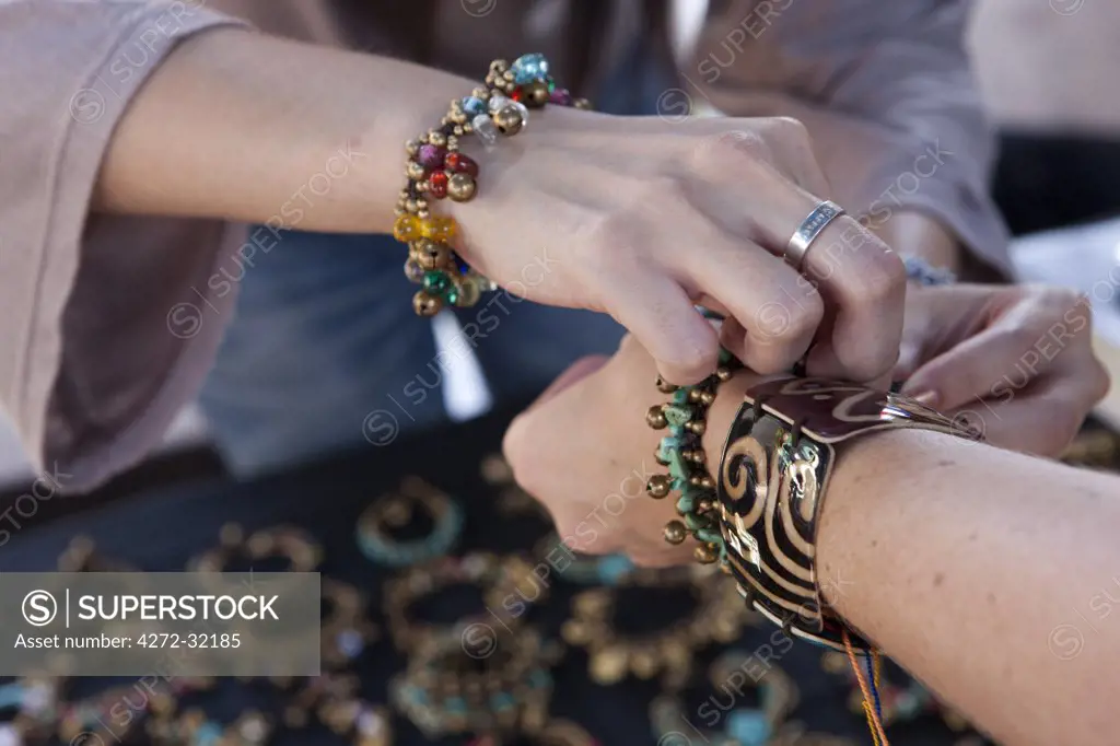 A western tourist buying jewelry in a market in Bangkok Thailand