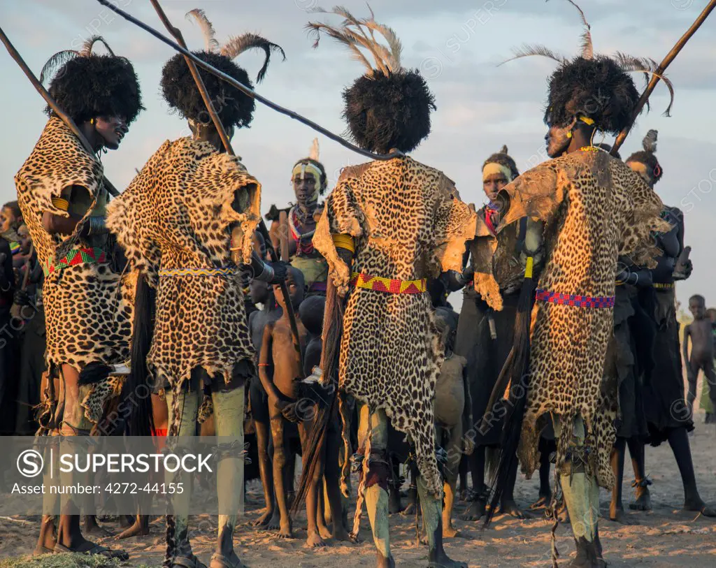 Dassanech men and their wives dressed in ceremonial regalia participate in a Dimi dance, Ethiopia