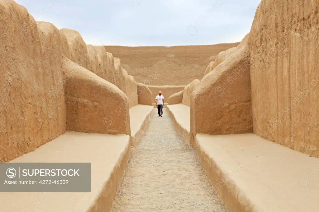 South America, Peru, La Libertad, Trujillo, a tourist walks along a corridor in the UNESCO World Heritage listed Chan Chan archaeological site, MR,