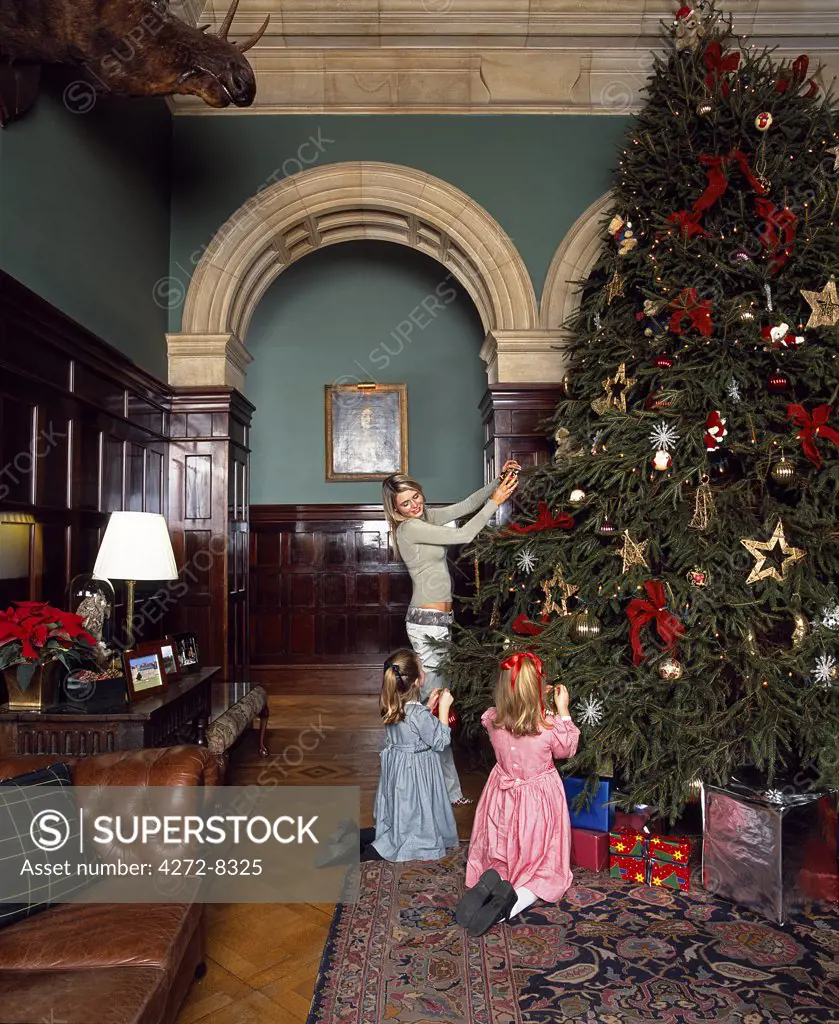 Children decorate the Christmas tree at Stapleford Park country house hotel