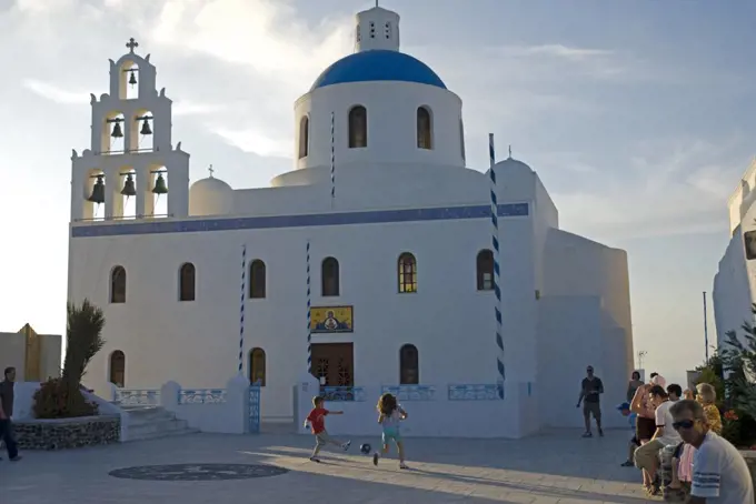 Greece, Santorini, Oia. Children playing  in the courtyard of a church in Oia.