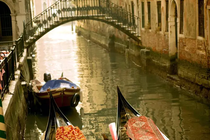 Italy, Veneto, Venice; Two gondolas tied up in a typically misty atmosphere with a bridge and the Gran Canal in the background