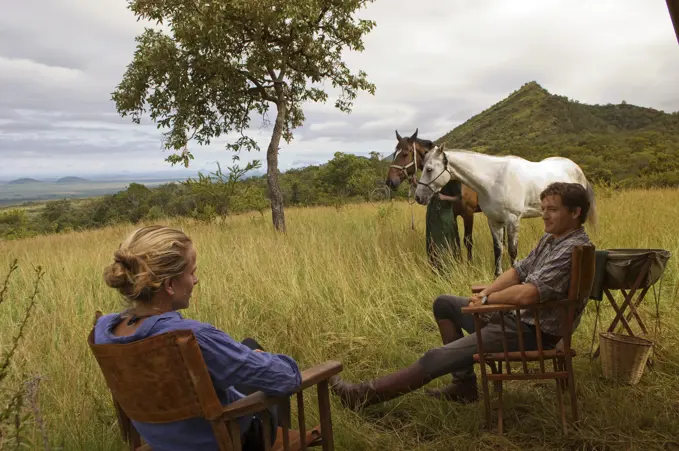 Kenya, Chyulu Hills, Ol Donyo Wuas. Couple on a horse riding safari with Ride Africa in the Chyulu Hills (MR)