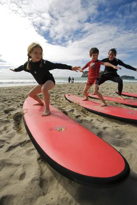 New Zealand, North Island, Coromandel Peninsula. Family surf lesson at Whangamata with Ricky Parker of Whangamata Surf School. (MR)