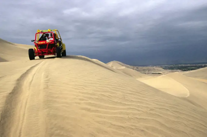 A dune buggy on the sand dunes bordering the city of Ica, in southern Peru