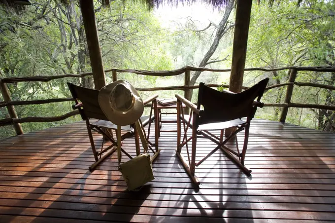 South Africa; North West Province; Madikwe Game Reserve. Canvas safari chairs on the private balcony of a cottage at Jaci's Safari Lodge.