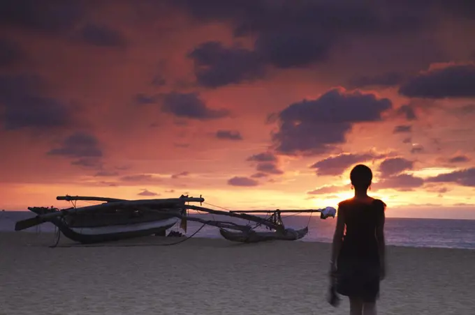 Woman walking on beach at sunset, Negombo, Sri Lanka (MR)