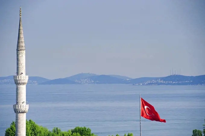 Turkey, Istanbul. Turkish flag and minaret.Blue Mosque