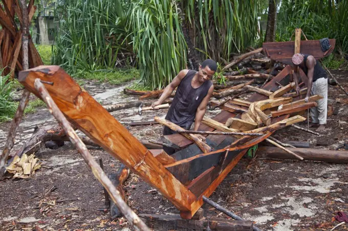 Tanzania, Zanzibar. Craftsmen build a dau, a wooden sailing boat commonly called a dhow, on Nungwi beach at the northern tip of Zanzibar Island. The hardwood is brought from the mainland.