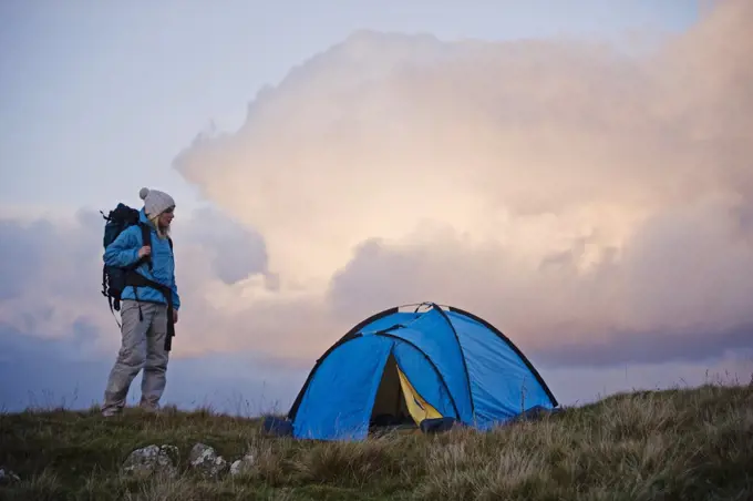 North Wales, Snowdonia, Gilar Farm.  Woman camping in the wild.