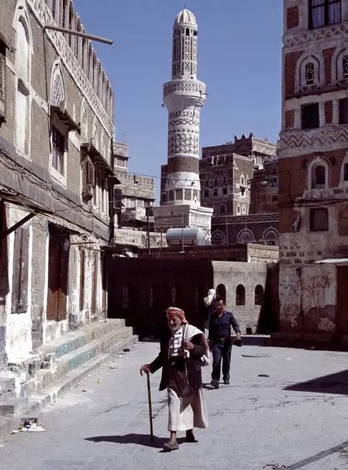 An old man walks along a street in Old Sanaa. Surrounded by a massive 20 to 30 foot high wall, old Sanaa is one of the worlds oldest inhabited cities. Several stone and brick buildings date back to the 11th Century AD, many are over 400 years old.