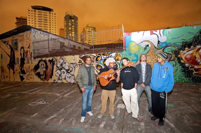 South America, Brazil, Sao Paulo, Vila Madalena, musicians in the Beco do Batman   an alley covered in Brazilian graffiti under the yellow neon glow of the Sao Paulo sky MR