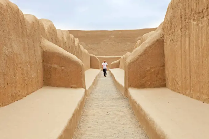 South America, Peru, La Libertad, Trujillo, a tourist walks along a corridor in the UNESCO World Heritage listed Chan Chan archaeological site, MR,