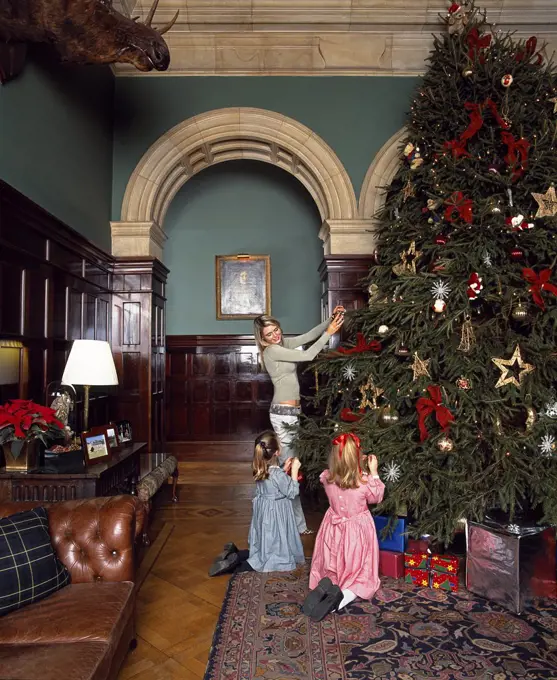 Children decorate the Christmas tree at Stapleford Park country house hotel