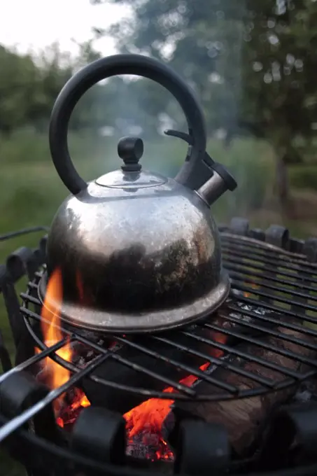 England, Isle of Wight. Kettle boiling on an open fire at Island Yurts, near Freshwater Bay.