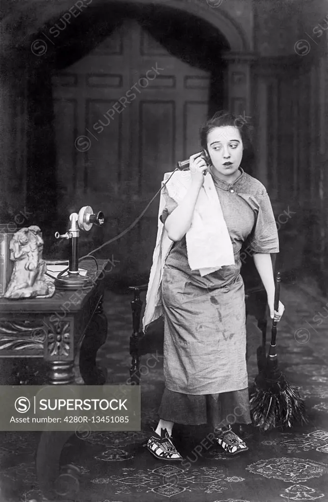 Housekeeper looking disheveled listening on the telephone All persons depicted are not longer living and no estate exists Supplier warranties that the...