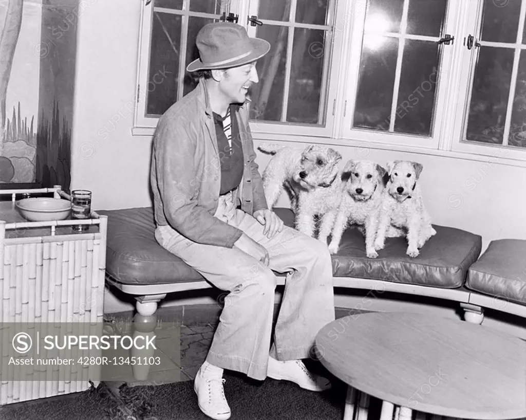 Man sitting on a bench with his three dogs All persons depicted are not longer living and no estate exists Supplier warranties that there will be no m...