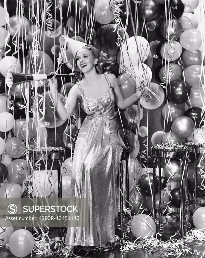 Woman celebrating with room full of balloons All persons depicted are not longer living and no estate exists Supplier warranties that there will be no...