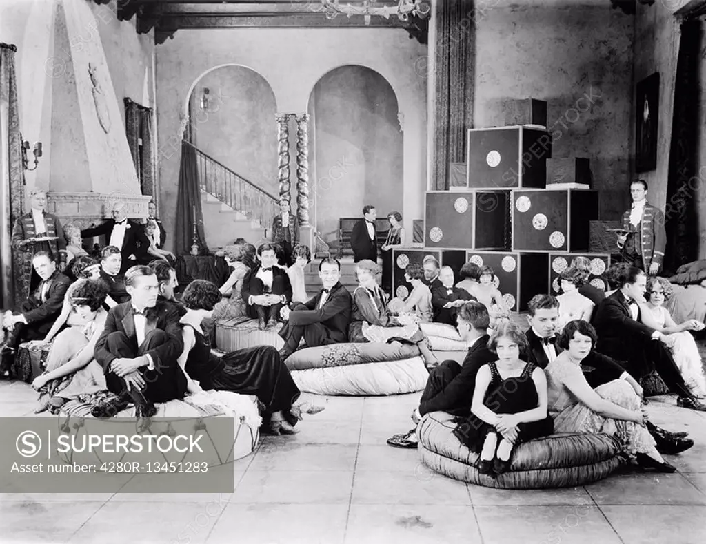 Group of people sitting on oversized cushions in a hall All persons depicted are not longer living and no estate exists Supplier warranties that there...