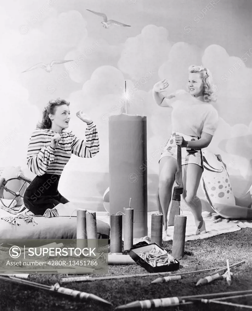 Two women sitting around fire works All persons depicted are not longer living and no estate exists Supplier warranties that there will be no model re...