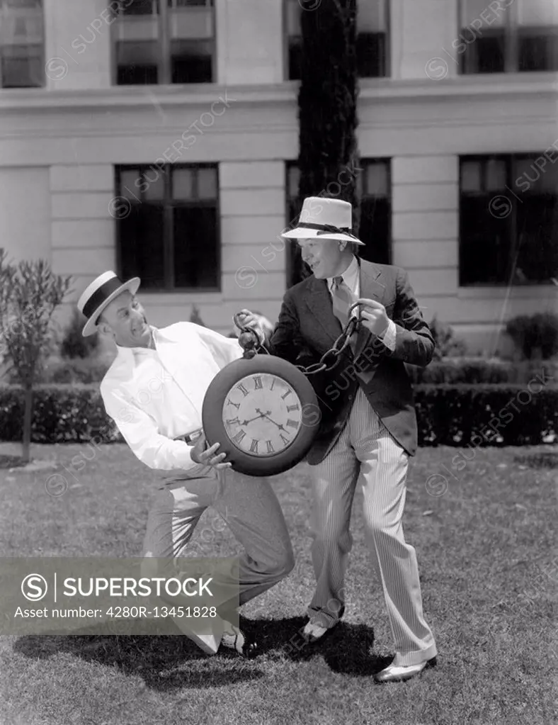 Two men wrestling with an oversized pocket watch All persons depicted are not longer living and no estate exists Supplier warranties that there will b...