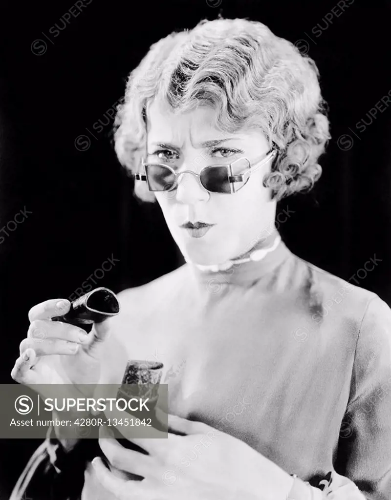 Young woman with unusual eyeglasses holding an open box All persons depicted are not longer living and no estate exists Supplier warranties that there...