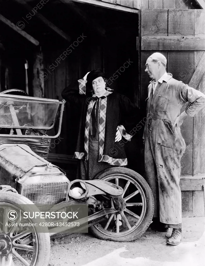 Man and woman looking at a wrecked car in the barn All persons depicted are not longer living and no estate exists Supplier warranties that there will...