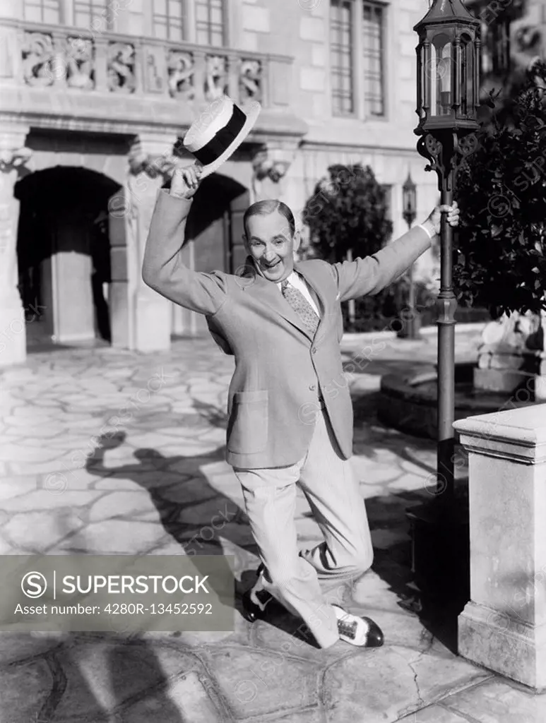 Man dancing in the street waving his hat All persons depicted are not longer living and no estate exists Supplier warranties that there will be no mod...