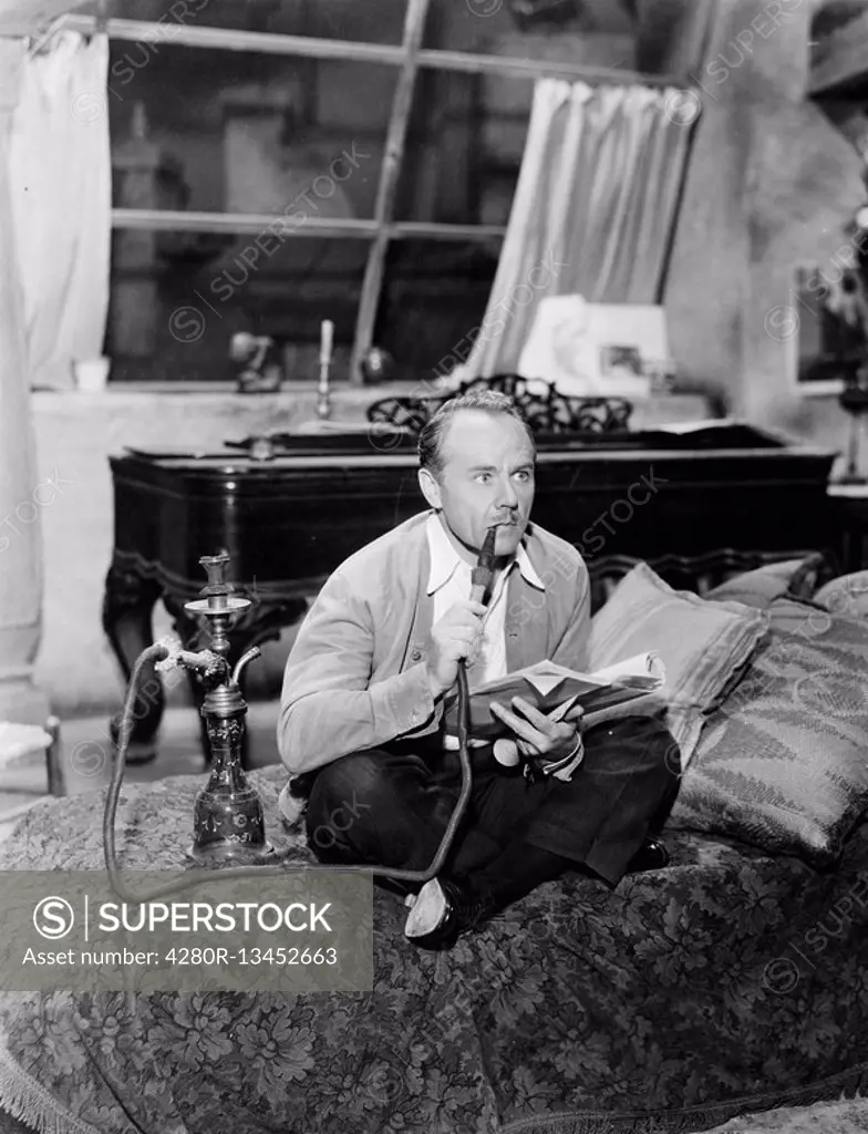 Man sitting on a bed smoking his water pipe All persons depicted are not longer living and no estate exists Supplier warranties that there will be no ...