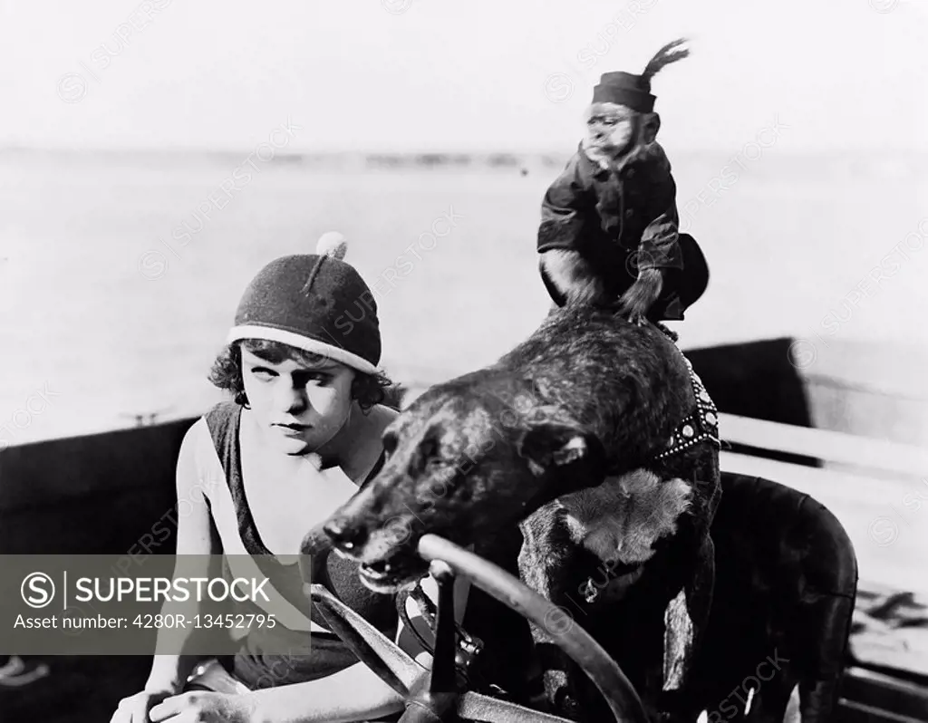 Teenage girl sitting in a motorboat driven by a dog All persons depicted are not longer living and no estate exists Supplier warranties that there wil...