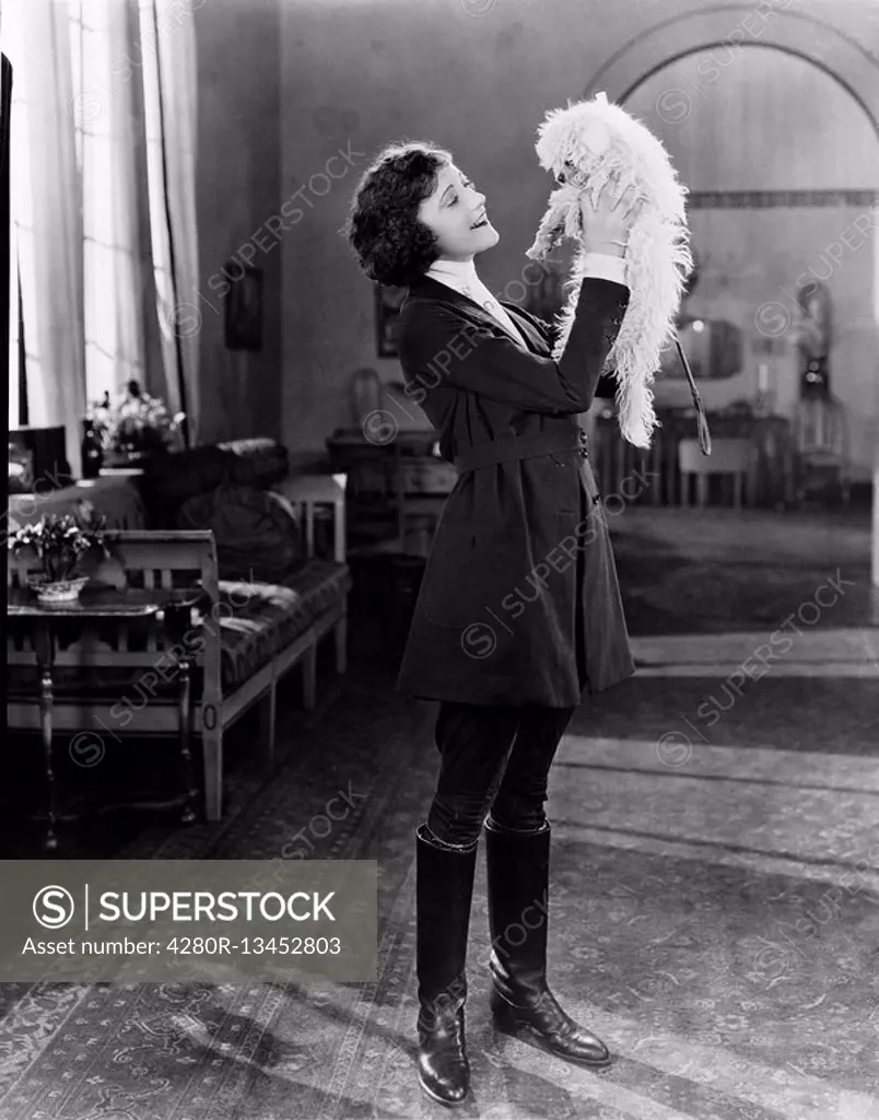 Young woman playing with her dog All persons depicted are not longer living and no estate exists Supplier warranties that there will be no model relea...