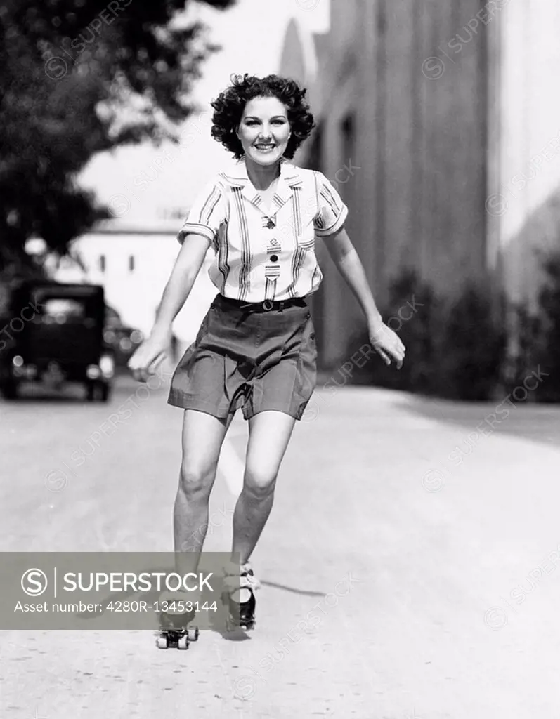 Portrait of a young woman skating on the road and smiling All persons depicted are not longer living and no estate exists Supplier warranties that the...