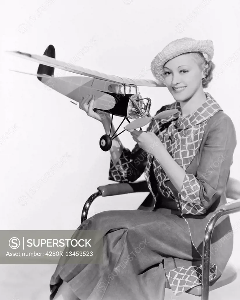 Woman holding a toy plane All persons depicted are not longer living and no estate exists Supplier warranties that there will be no model release issu...