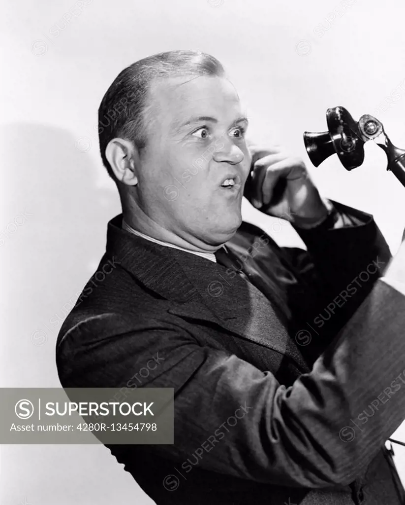 Man with funny expression using telephone All persons depicted are not longer living and no estate exists Supplier warranties that there will be no mo...