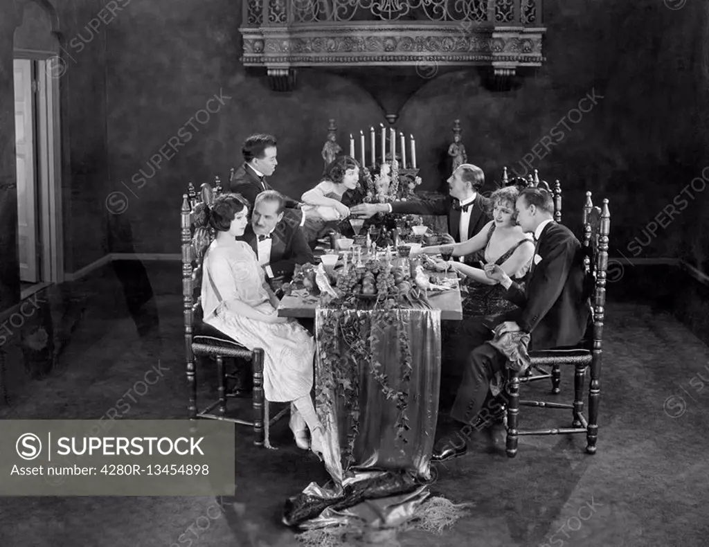 Group of people having dinner party All persons depicted are not longer living and no estate exists Supplier warranties that there will be no model re...